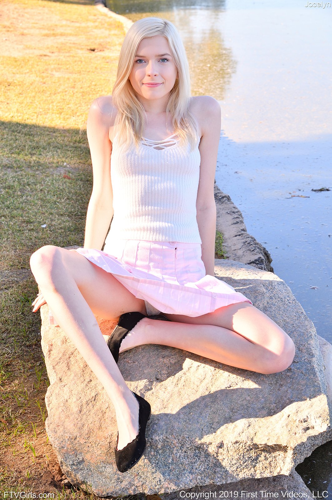 Faded-skinned blonde in a white costume reveals all of it by the water