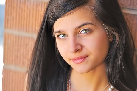 Playful dark-haired girl shows her slim body while posing in the kitchen