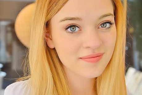 Baby-faced teen shows her pink pussy while posing on the couch